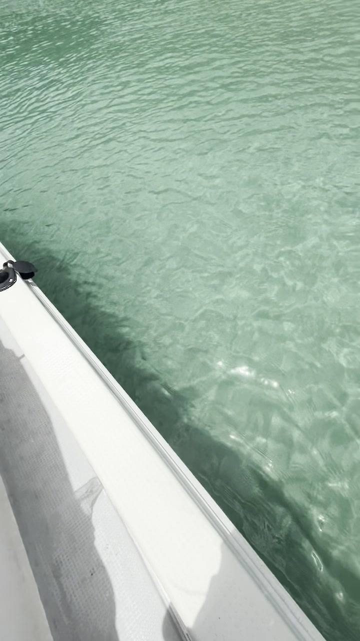 Clear turquoise water along the white side of a small boat.